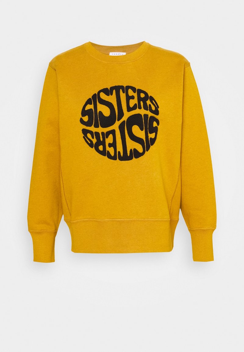 Sudadera amarilla con texto redondo negro "SISTERS" en una fuente retro. Cuenta con cuello redondo y puños acanalados. Textura suave.