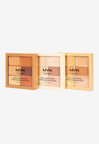 Trois palettes carrées de correcteur NYX, comprenant chacune six teintes. L'emballage est doré avec un texte noir audacieux, variant des tons clairs aux tons foncés.