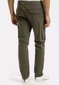 Oliwkowe spodnie cargo o luźnym kroju, wykonane z trwałego materiału. Posiadają wiele kieszeni bocznych oraz pasek w pasie z pętelkami.