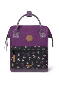 Purple corduroy bag with a textured finish, featuring a floral-patterned black front pocket and a round logo patch. Two handles on top.