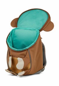 Mochila de tela marrón con un suave interior turquesa, orejas de mono redondeadas y acentos crema; cuenta con una apertura con cremallera y un respaldo de malla.