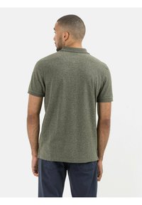 Korte mouwen polo in gestructureerde olijfgroene stof met een klassieke kraag, voorzien van een rechte zoom en zonder zichtbare merknaam.