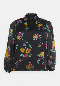Sorte bluse med v-hals og puffede ærmer, prydet med et blomstermønster i gul, pink og grøn på gennemsigtigt stof.