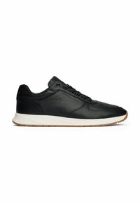Sneakers in pelle nera con una texture liscia, dotati di una suola intermedia bianca, suola in gomma e occhielli metallici per i lacci.