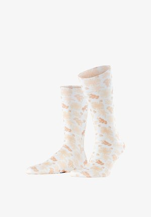 Weiße Sportsocken mit beigen abstrakten Blumen- und Blattmustern, dargestellt mit einem leicht nach vorne geneigten Fuß auf weißem Hintergrund.