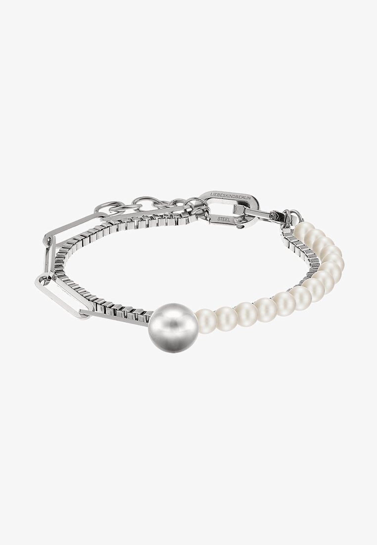 Bracelet en ton argent, composé d'un mélange de perles blanches et d'un gros perle argentée, avec un design géométrique et un fermoir ajustable.