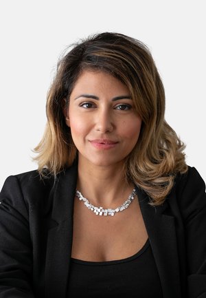 Collana d'argento con maglie quadrate e rettangolari, caratterizzata da una superficie texturizzata. Indossata con un blazer nero e una maglietta su uno sfondo bianco.