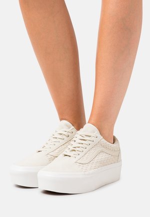 Hvide ruskindssneakers med vævet detalje på siderne, flade hvide gummisåler og flad snørelukning. Minimalistisk design uden pynt.