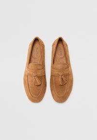 Lette semskede loafers med rund tå, dekorative duskdetaljer og innvendige sømdetaljer. Flate såler og slip-on design for enkel påkledning.