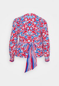 Blusa rossa con stampa floreale e d'uccelli blu e bianca, maniche lunghe, polsini con bottoni e un fiocco in vita a strisce blu, bianche e rosse sul retro.
