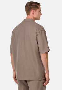 Camicia a maniche corte in lino marrone chiaro. Caratterizzata da un colletto classico e una vestibilità rilassata, con un tessuto morbido e texturizzato e orlo dritto.