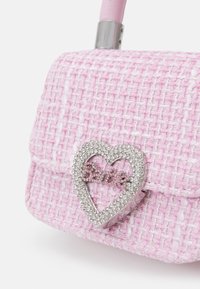 Sac à main en tweed rose avec un fermoir en forme de cœur en strass portant le mot "Barbie" en lettres scintillantes.