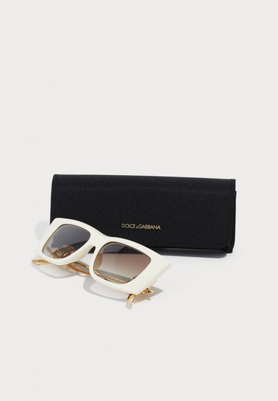 Sluneční brýle Dolce & Gabbana s bílým oversized rámem a gradientními čočkami, doplněné černým textilním pouzdrem s zlatým logem.