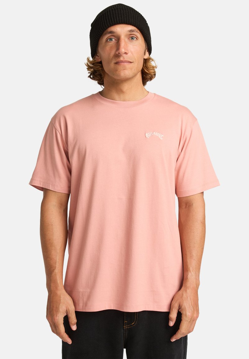 T-shirt rosa chiaro a maniche corte realizzata in cotone con scollatura rotonda. Presenta un piccolo logo bianco sul petto. Vestibilità comoda.