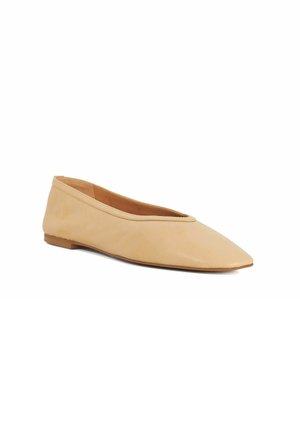 Chaussure plate beige en cuir pour femme avec bout pointu et talon bas, vue de côté sur fond blanc.