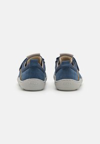 Marineblaue Schuhe mit einem strukturierten Obermaterial aus Wildleder und Mesh, grauen Akzenten und einer Gummisohle. Mit gepolstertem Kragen und dezentem Logo an der Ferse.