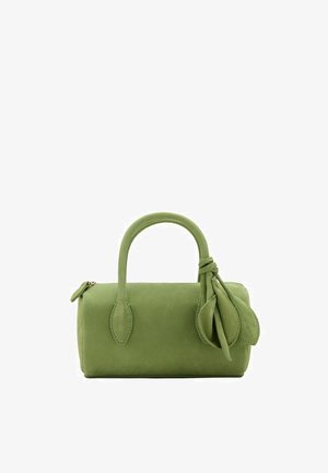 Sac à main en daim vert avec des poignées arrondies et des accents décoratifs en forme de feuille attachés à une poignée, sur fond blanc.