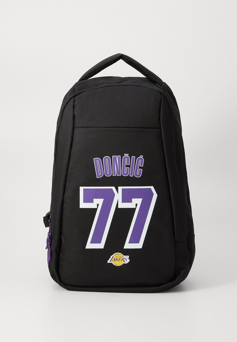 Fekete hátizsák lila részletekkel, amelyen a "DONČIĆ" név és a "77" szám vastag fehér betűkkel van nyomtatva. Az oldalon Lakers-logo található.