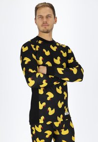 Black, long-sleeve top featuring a repeating pattern of yellow rubber ducks with red beaks. Ribbed texture and fitted design.