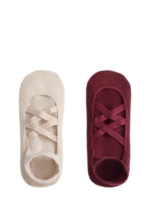 Deux couvre-chaussures tricotés de style ballet, l’un crème et l’autre bordeaux, avec des brides élastiques croisées et des talons ouverts.