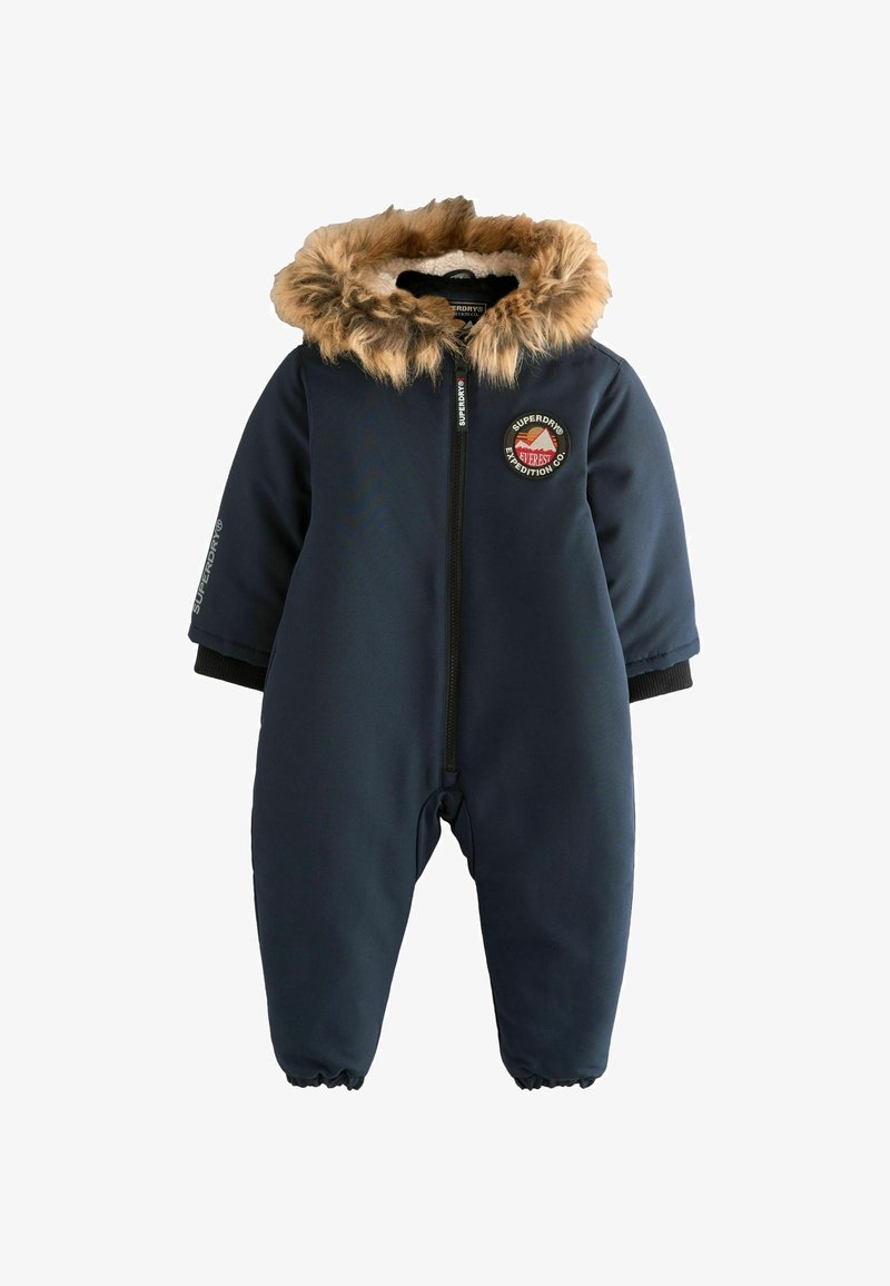 Navyblauwe sneeuwoverall met een nepbont-voering in de capuchon, rits aan de voorkant, ribgebreide manchetten en een logo-patch op de borst. Zachte, gladde stof met elastische manchetten.