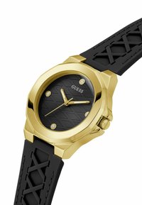 Runde schwarze Uhr mit strukturiertem Zifferblatt, goldfarbener Gehäuse, vier Kristall-Stundenmarkierungen und schwarzem Gummiband mit Kreuzmuster.