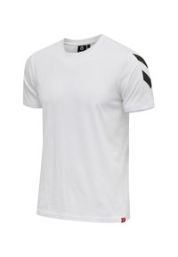 Hvid bomulds t-shirt med rund hals, korte ærmer og sorte chevron-detaljer på venstre skulder. Har et lille rødt logo mærke nederst.