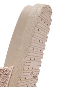 Platform sandaal met een gestructureerde, beige rubberen zool met ribbels, en een roze bovenzijde versierd met een ruitjespatroon van gaas en kleine versieringen.
