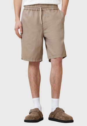Pantalones cortos de algodón beige con cintura elástica y cordón, que cuentan con bolsillos laterales y un ajuste relajado.