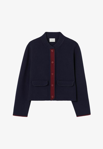 Cardigan ribbed navy con colletto rotondo, placca dei bottoni bordeaux e due tasche frontali. Presenta un bordo rosso a contrasto lungo l'orlo.