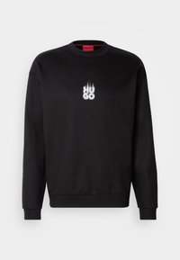 Sweat-shirt noir col rond avec manches longues et petit texte blanc "HUGO" avec motif de flammes centré sur la poitrine.