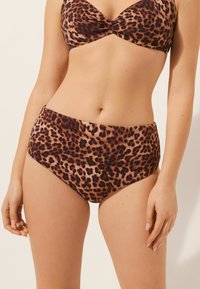 Bikini med leopardmönster som har en vadderad, knuten topp och högmidjade bottnar med en slät textur, i jordnära bruna och tan nyanser.