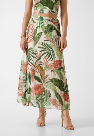 Maxi spódnica z kwiatowym wzorem zielonych i różowych liści na kremowym tle, wykonana z lekkiego materiału o lejącym się kroju.