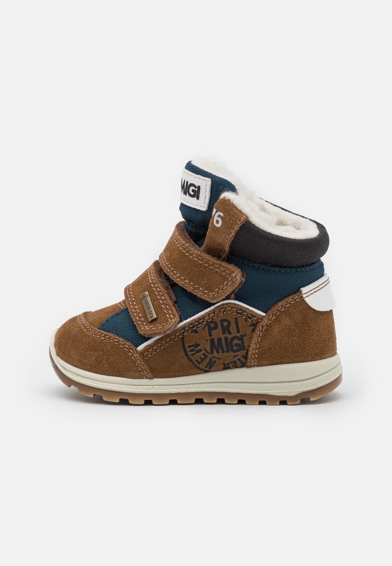 Baskets montantes pour enfants marron et bleu marine avec double fermeture velcro, doublure polaire et semelle en caoutchouc texturée sur fond blanc.