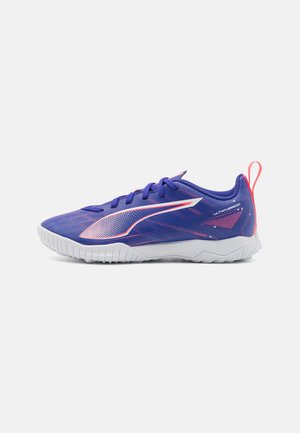 Fioletowe buty sportowe z teksturowaną siateczką na cholewce, białą podeszwą i różowymi akcentami. Posiadają logo po boku oraz uchwyt przy pięcie.