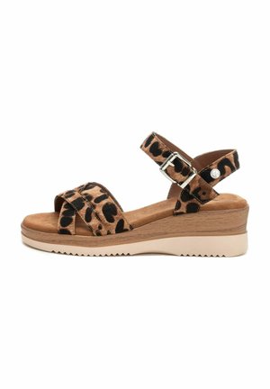 Sandalia de cuña con estampado de leopardo y correa desmontable en el tobillo, textura similar al ante, plantilla marrón claro y suela gruesa blanca contrastante.