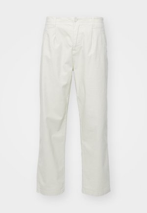 Svetlo bež bombažne hlače s ravnim krojem, ki vključujejo gumbni sklep, zanke za pas in sprednje gube za dodatno strukturo.