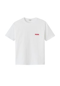 T-shirt en coton blanc avec des manches courtes et un col rond. L'avant affiche le texte "MORE" en rouge. Texture lisse, coupe décontractée.