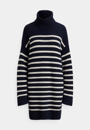 Tummansininen neulemekko, jossa on beigeitä vaakaraitoja ja paksu poolokaulus, valkoisella taustalla.