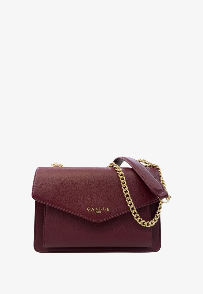 Borsa a mano in pelle bordeaux con tracolla in catena dorata. Presenta una chiusura a patta in stile busta e un logo impresso sul fronte. Superficie texturizzata.