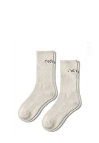 Chaussettes basses en coton de couleur gris clair, présentant un design côtelé et un texte imprimé "rethink" sur le bord. Texture douce et hauteur moyenne.