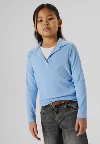 Hellblaues, geripptes Langarmshirt mit Kragen, kombiniert mit dunkelgrauen, ausgebleichten Jeans und einem braunen Gürtel.
