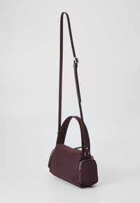 Borsa a tracolla color bordeaux con tracolla regolabile, forma rettangolare, texture liscia, con zip in tonalità argento su entrambi i lati.