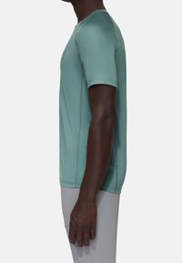 Short-sleeve athletic shirt in light teal, made of smooth, stretchy material. Features contrasting seams and a fitted silhouette.