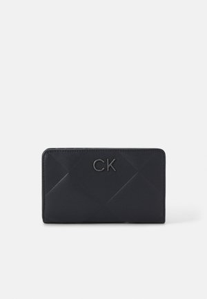 Black leather wallet featuring a quilted pattern, silver CK logo, and a rectangular shape. Smooth texture with subtle sheen.