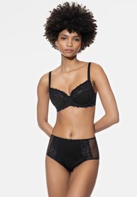 Zwarte kanten bh met een gegolfde rand en beugel, gecombineerd met hoge zwarte slipjes met doorschijnende kantpanelen aan de zijkanten.