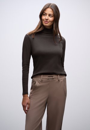 Bruine langslouwe turtleneck top gecombineerd met beige, hoog-gesneden broeken met een vlakke voorkant en zijzakken; gladde, aansluitende textuur.