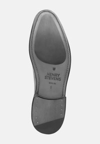 Schwarze Ledersohle mit eingraviertem Markennamen "HENRY STEVENS BERLIN", geschwungenen Kanten, glatter Oberflächenstruktur und Metallnieten entlang der Ferse.