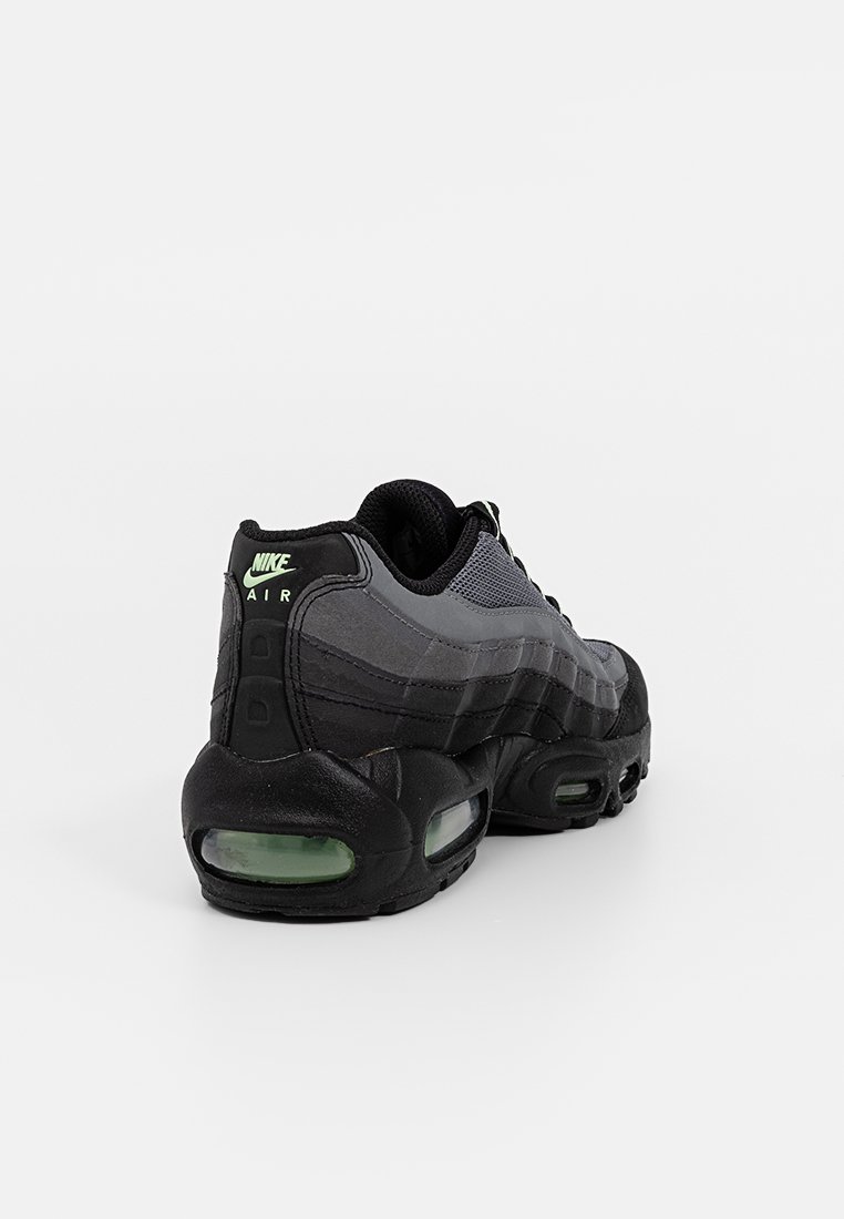 Sneaker Nike Air Max 95 noir, tige en mesh et synthétique, motif texturé, semelle noire avec amorti en vert, accents réfléchissants.