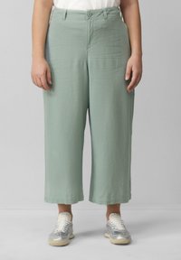Lichtgroene, hoge taille, wijde broek gemaakt van lichte stof. Voorzien van een knoopsluiting aan de voorkant en zijzakken.